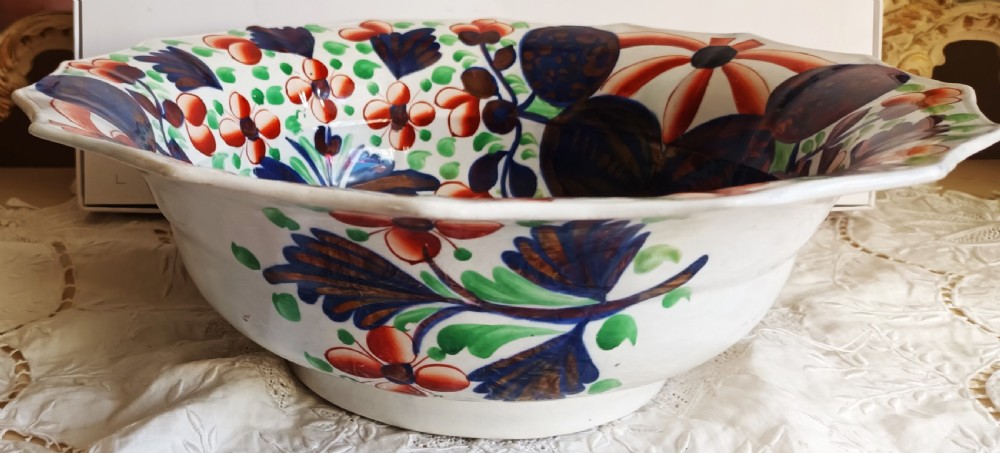 An octagonal Victorian ceramic toilet basin featuring hand-painted Gaudy Welsh Celyn pattern floral designs in cobalt blue, rust red, and green with copper lustre detailing on a white glaze. View VII