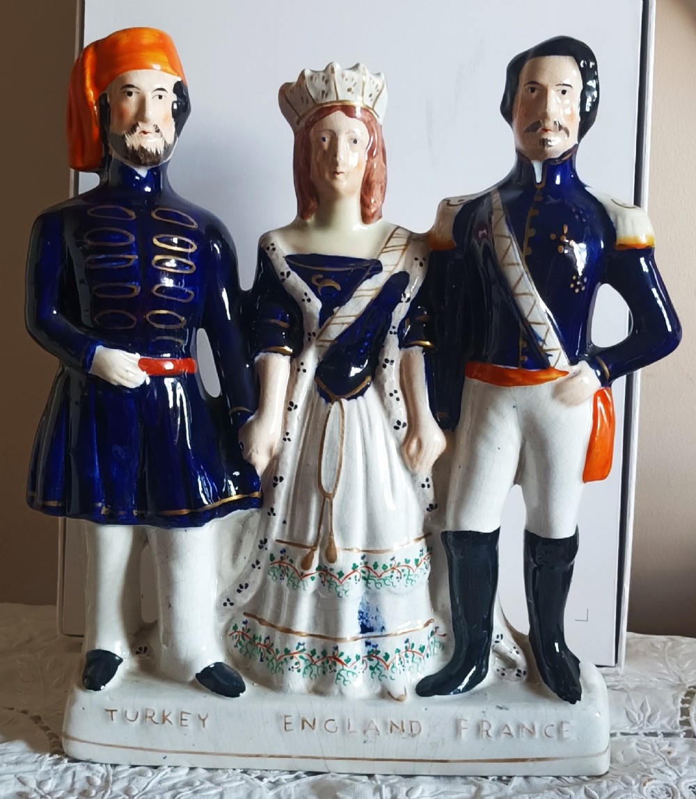 An antique Victorian Staffordshire pottery flatback figure depicting three historical figures representing Turkey, England, and France in uniform with gilded accents.