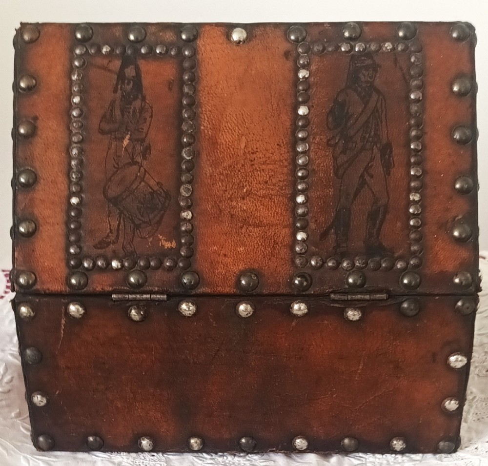 A rectangular Georgian leather-bound casket decorated with brass studs, etched military figure illustrations, and a central iron latch. View IV