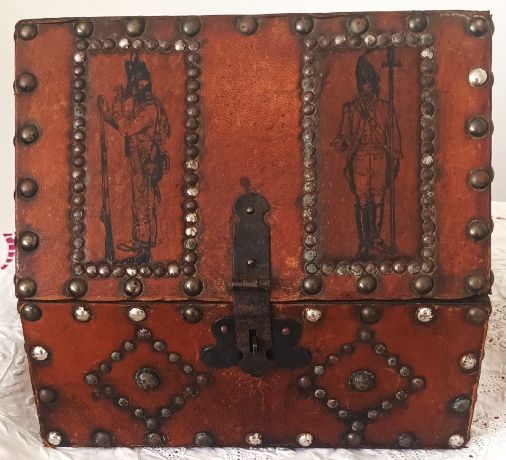 A rectangular Georgian leather-bound casket decorated with brass studs, etched military figure illustrations, and a central iron latch. View VIII