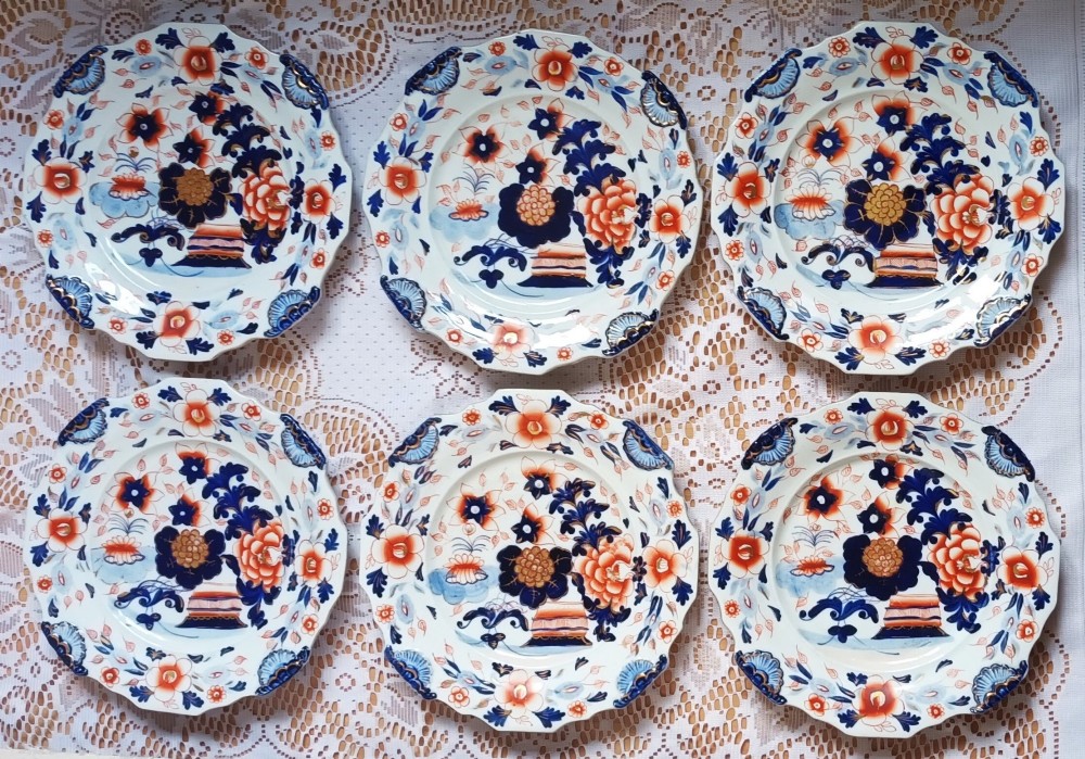 Set of six scalloped antique ironstone plates decorated with cobalt blue and terracotta floral Imari patterns with gilded details.
