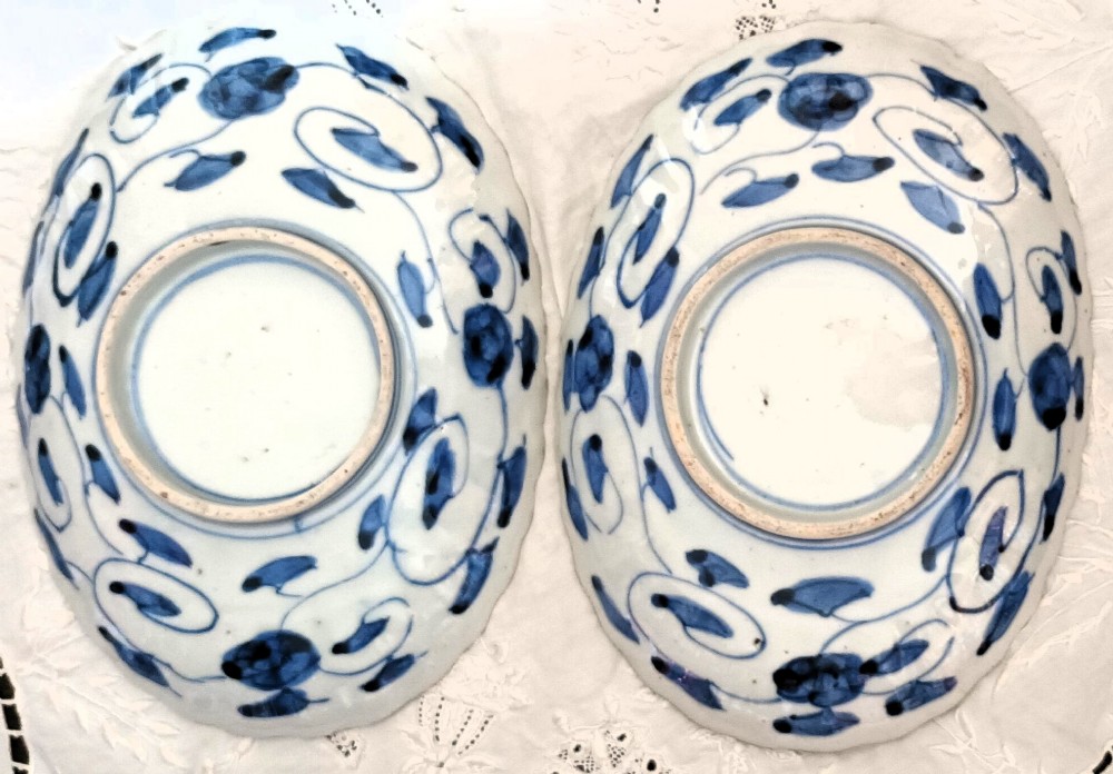 A pair of oval antique Japanese Imari porcelain dishes with scalloped rims, featuring hand-painted floral and bird motifs in cobalt blue, iron red, and white enamels. View II