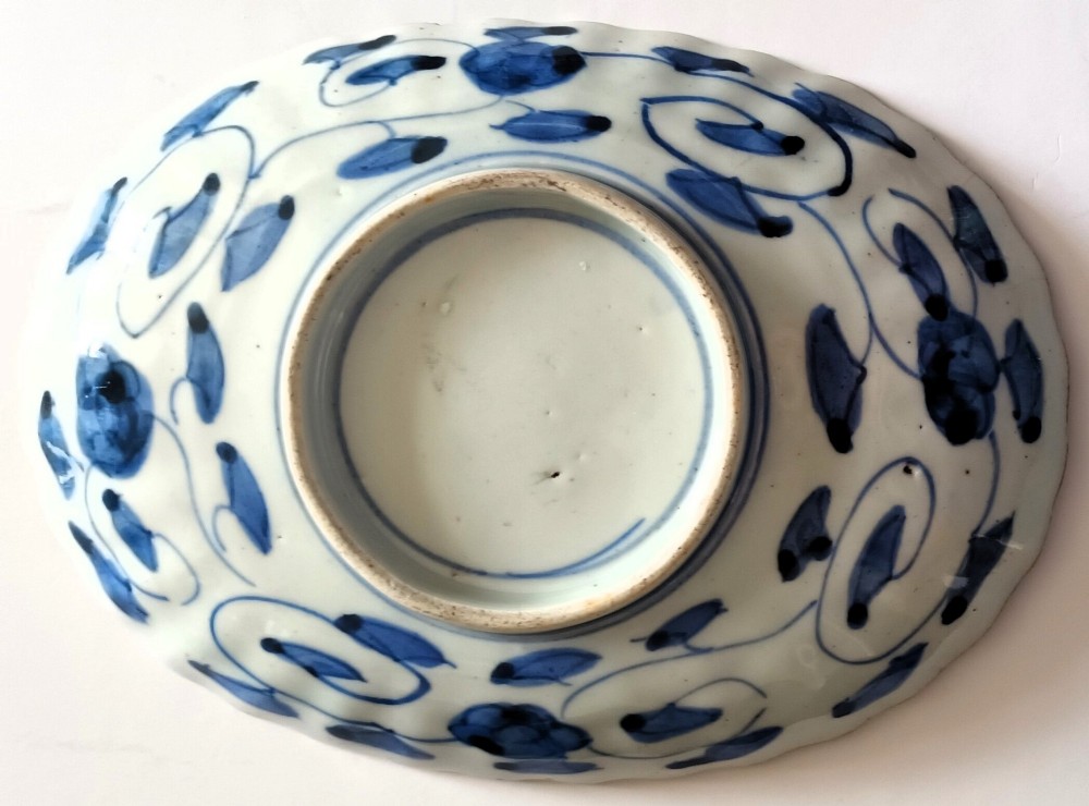 A pair of oval antique Japanese Imari porcelain dishes with scalloped rims, featuring hand-painted floral and bird motifs in cobalt blue, iron red, and white enamels. View IV
