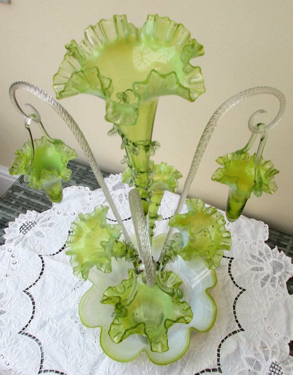 A Victorian vaseline glass epergne featuring a central ruffled trumpet vase, surrounding horns, hanging baskets, and a bowl base in yellow-green opalescent glass. View VIII