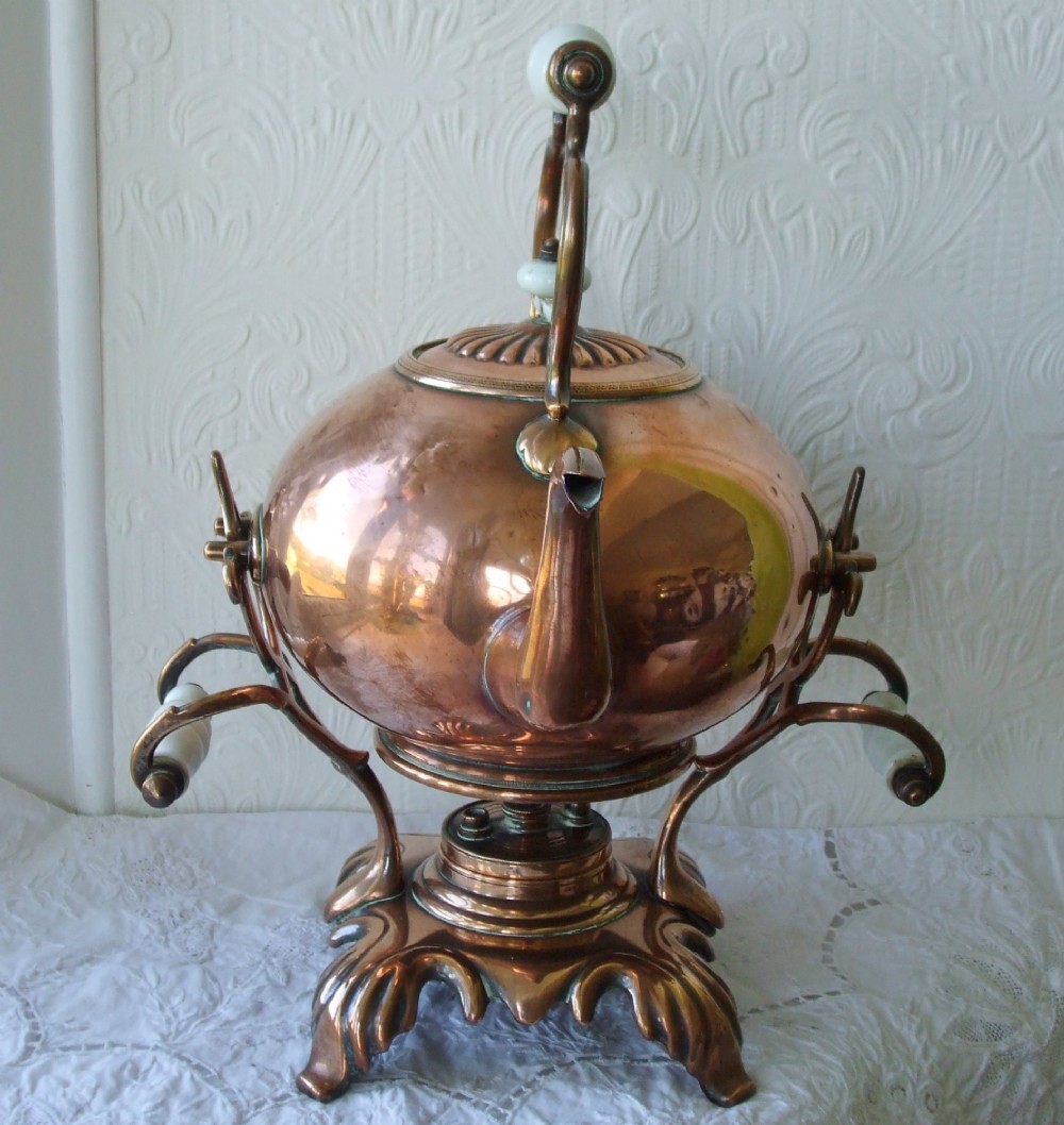 An antique Victorian copper spirit kettle featuring a white ceramic handle, gooseneck spout, and decorative brass stand with burner. View IV