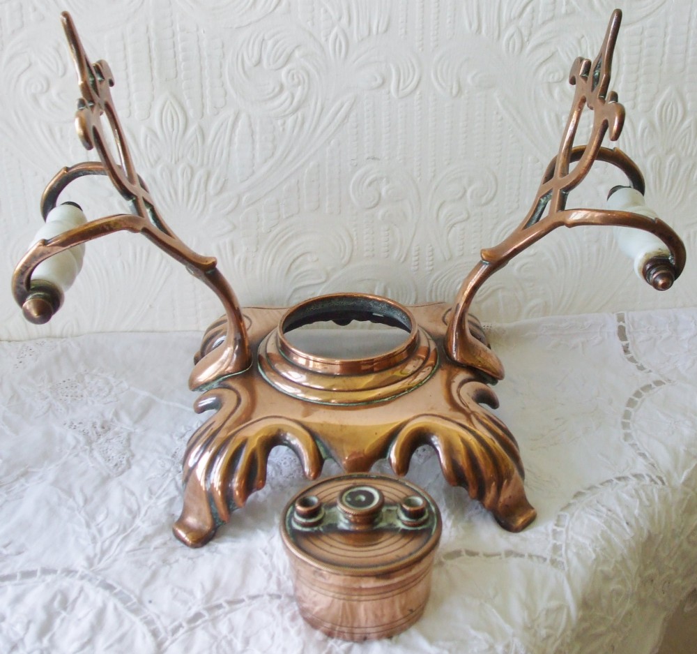 An antique Victorian copper spirit kettle featuring a white ceramic handle, gooseneck spout, and decorative brass stand with burner. View V