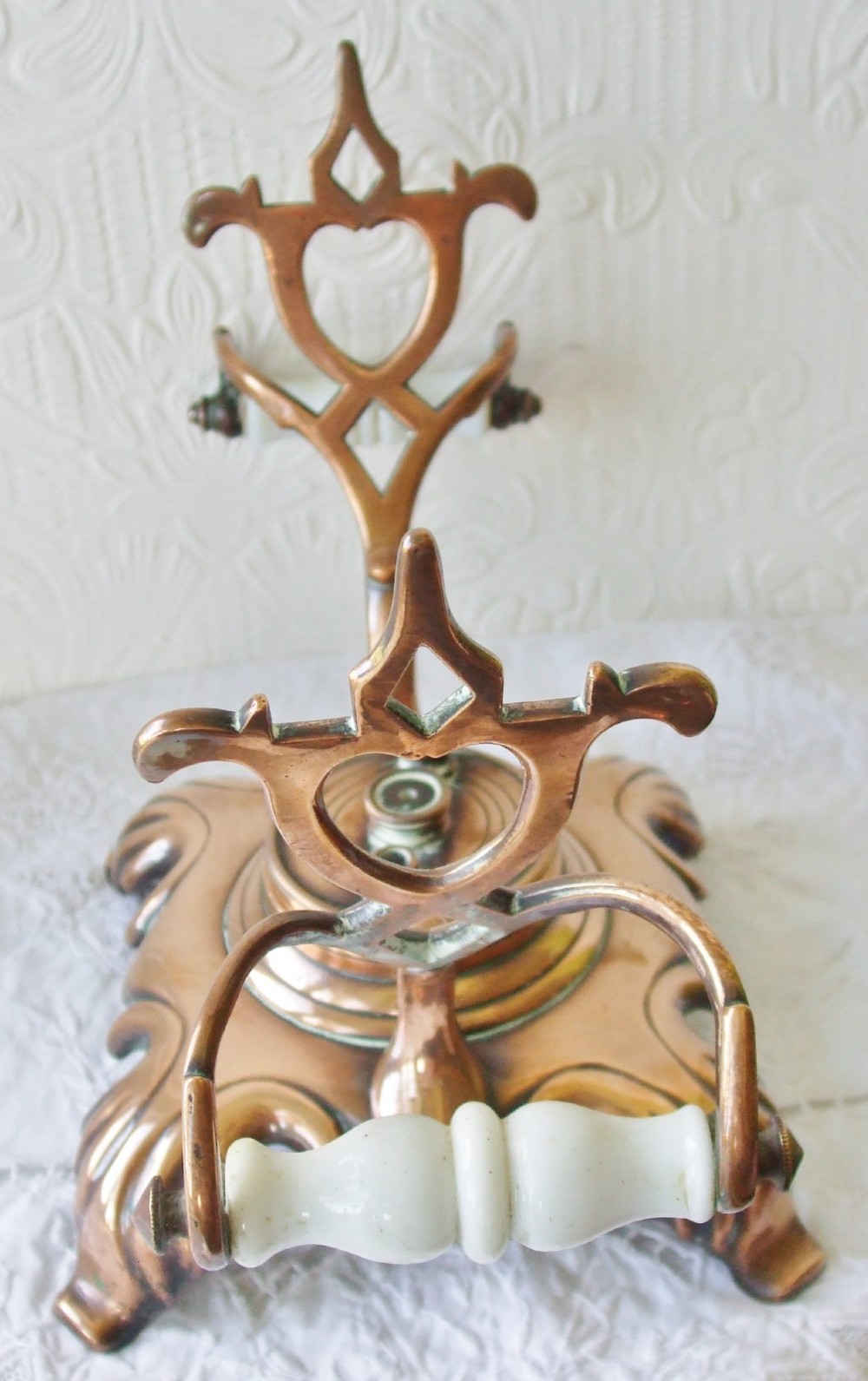 An antique Victorian copper spirit kettle featuring a white ceramic handle, gooseneck spout, and decorative brass stand with burner. View VI