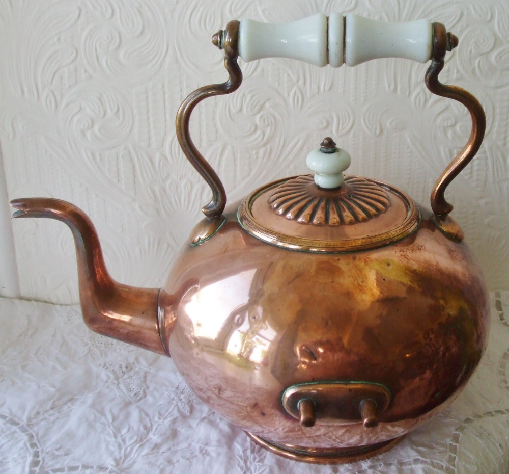 An antique Victorian copper spirit kettle featuring a white ceramic handle, gooseneck spout, and decorative brass stand with burner. View VIII