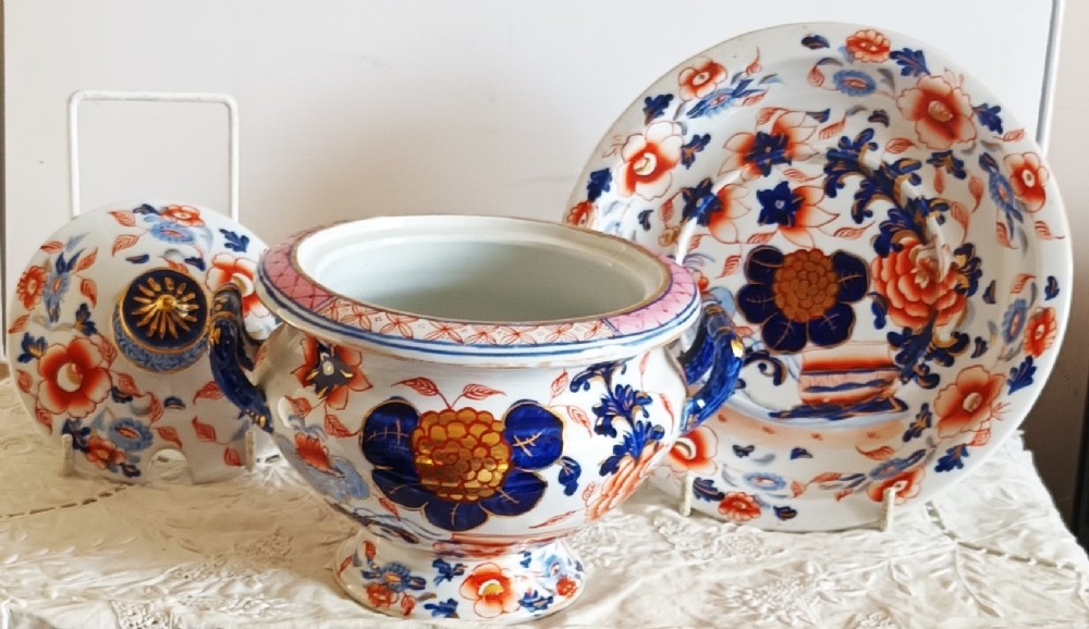 An antique Georgian ironstone china soup tureen with a lid and matching stand, decorated in an ornate Japanese Imari style pattern with cobalt blue, rust red, and gilded floral motifs. View V