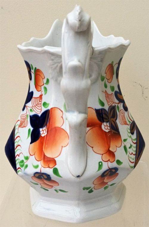 fig 1. A Victorian Gaudy Welsh earthenware jug decorated with the hand-painted Cambrian Rose pattern in cobalt blue, orange, and green on an octagonal white body.
