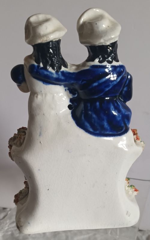 fig 2. A Victorian Staffordshire pottery figurine depicting two seated figures in Scottish dress set above a painted clock face.