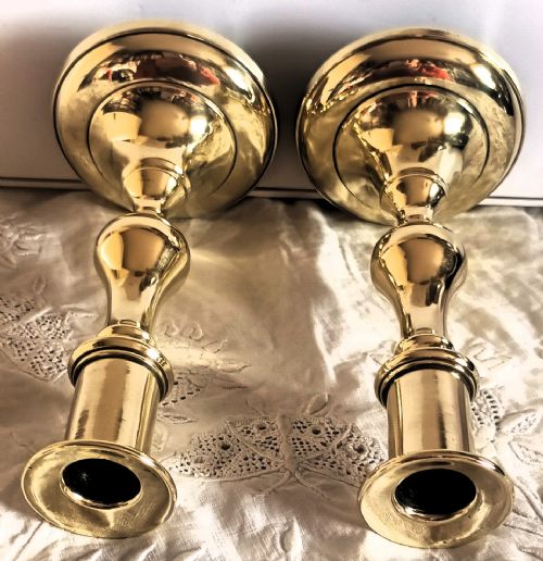 fig 2. A pair of polished gold brass candlesticks featuring baluster turned stems and stepped circular bases.