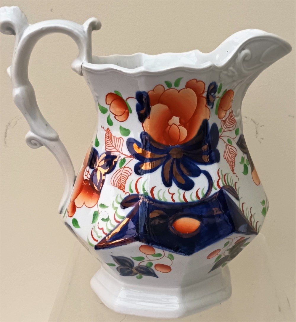 A Victorian Gaudy Welsh earthenware jug decorated with the hand-painted Cambrian Rose pattern in cobalt blue, orange, and green on an octagonal white body. View III