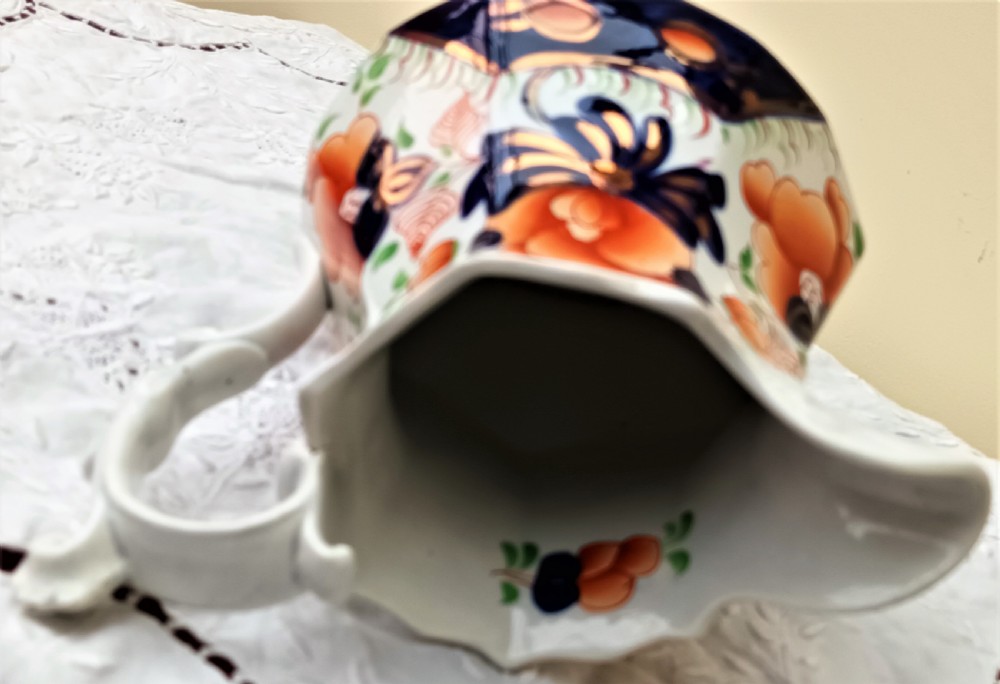 A Victorian Gaudy Welsh earthenware jug decorated with the hand-painted Cambrian Rose pattern in cobalt blue, orange, and green on an octagonal white body. View V