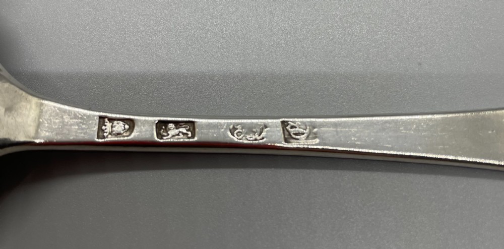A George II sterling silver tablespoon featuring an oval bowl, a slender stem, and an engraved monogram on the terminal. View V