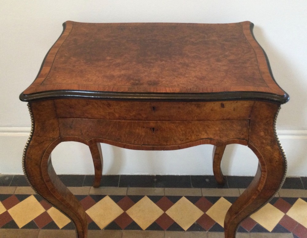 A late 19th-century burr walnut side table featuring serpentine edges, cabriole legs trimmed with brass studs, and a figured wood grain surface. View II