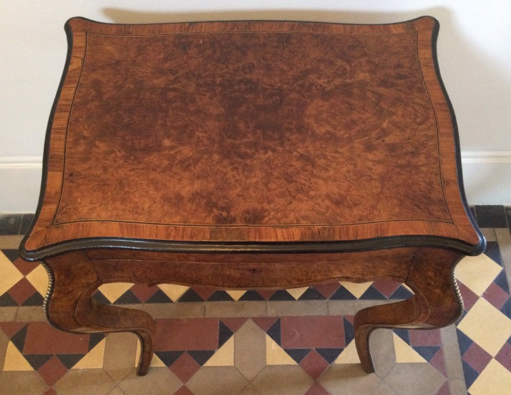 A late 19th-century burr walnut side table featuring serpentine edges, cabriole legs trimmed with brass studs, and a figured wood grain surface. View IV