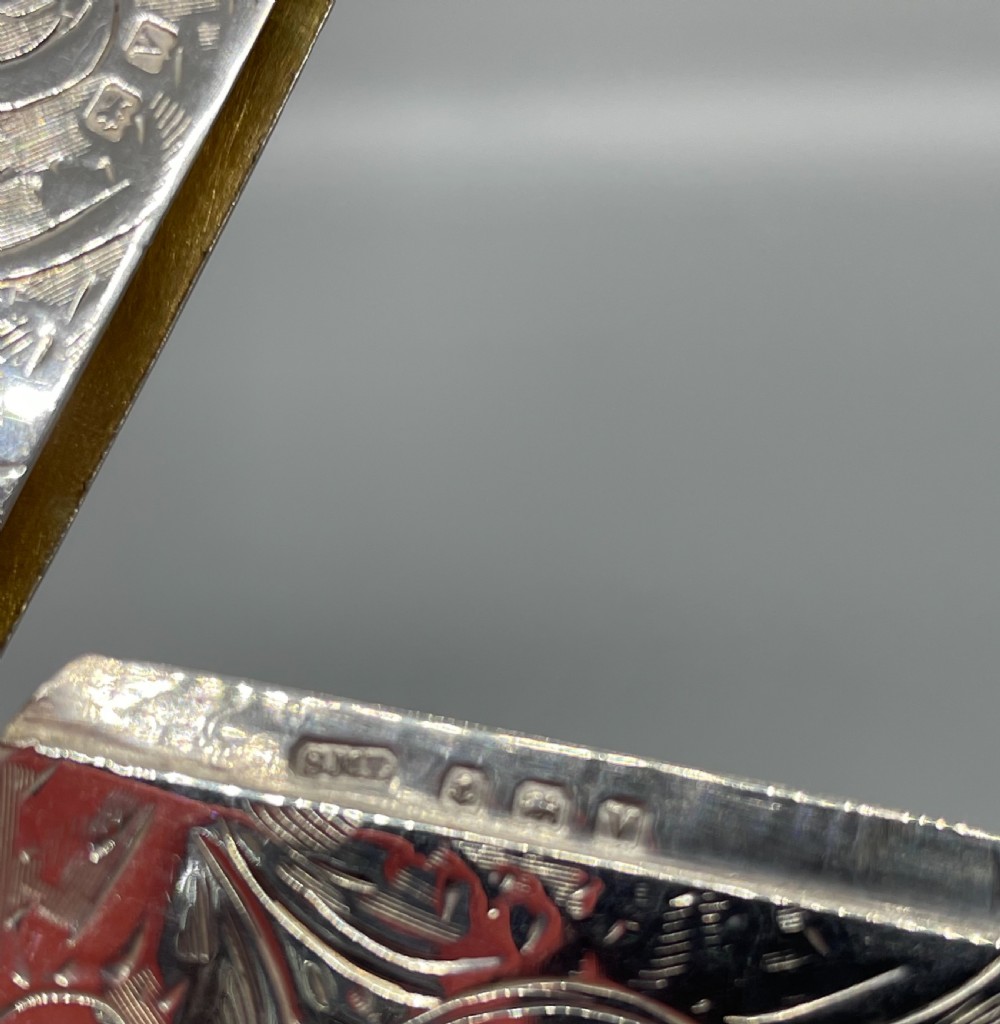 An engraved sterling silver card case featuring scrollwork patterns and a central circular cartouche. View IX