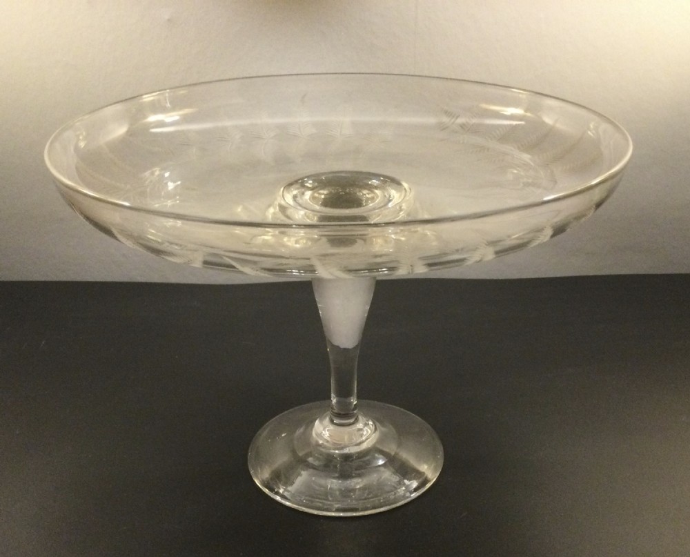 A clear Victorian lead crystal tazza featuring acid-etched fern leaves around the shallow circular dish, raised on a slender central stem and round footed base. View IV