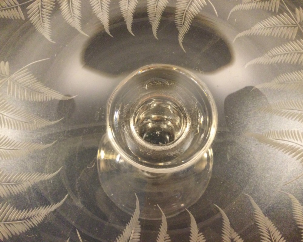 A clear Victorian lead crystal tazza featuring acid-etched fern leaves around the shallow circular dish, raised on a slender central stem and round footed base. View V