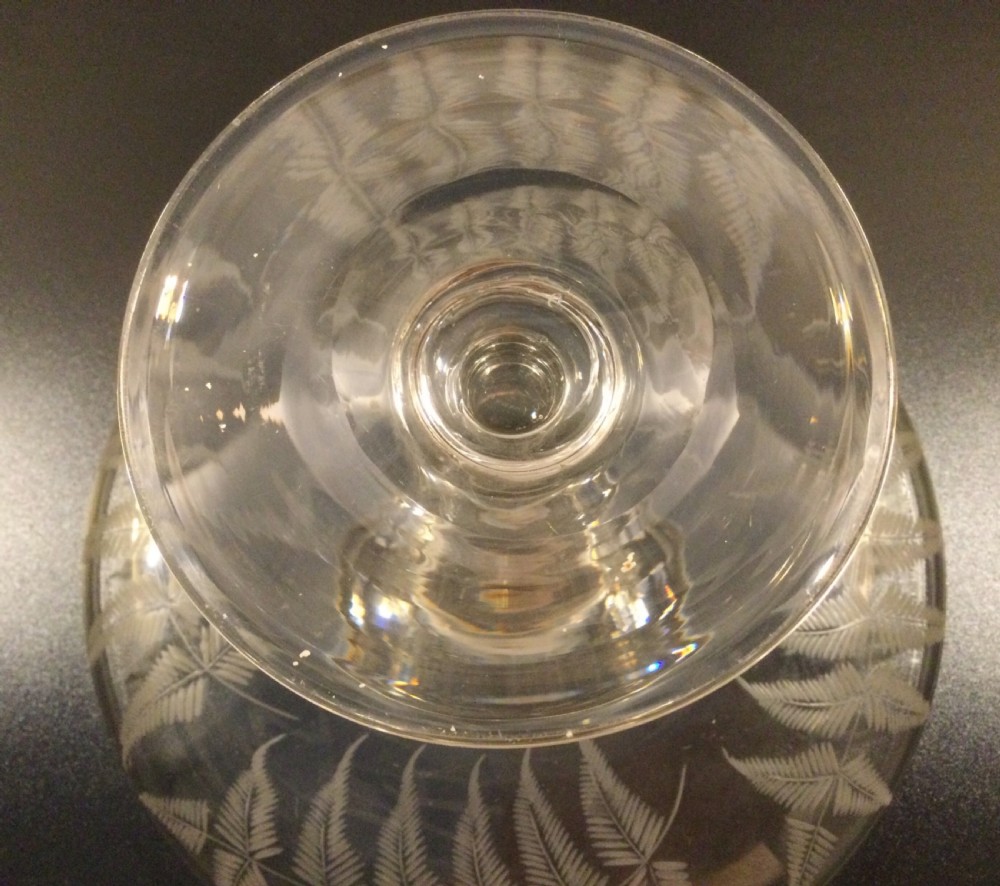 A clear Victorian lead crystal tazza featuring acid-etched fern leaves around the shallow circular dish, raised on a slender central stem and round footed base. View VII