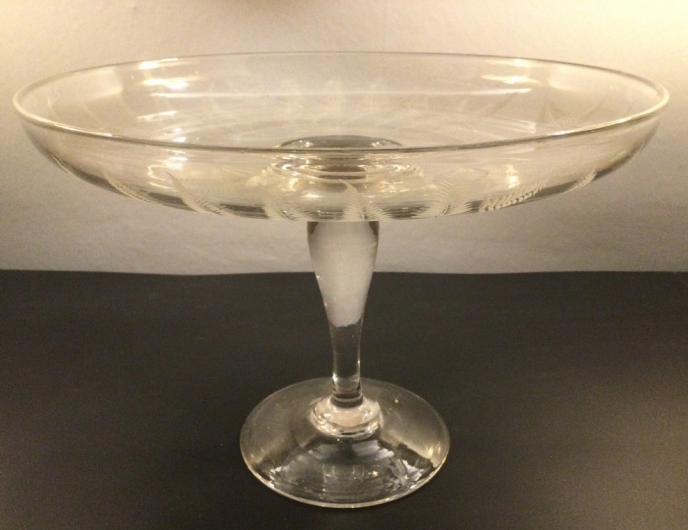A clear Victorian lead crystal tazza featuring acid-etched fern leaves around the shallow circular dish, raised on a slender central stem and round footed base. View IX