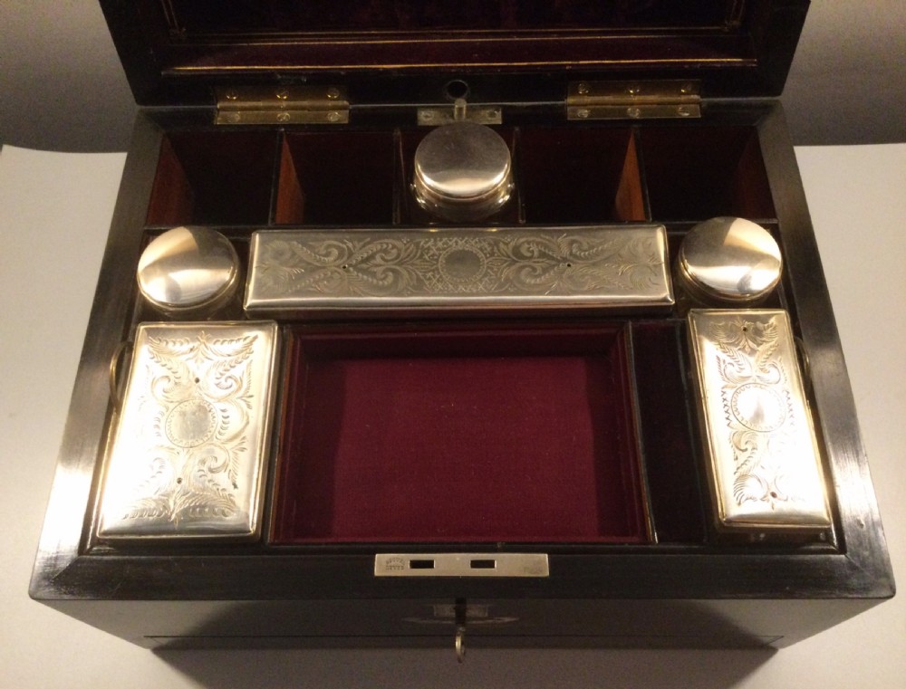 An early Victorian rectangular dark brown coromandel wood box featuring mother-of-pearl inlaid shield and crest motifs on the top lid and front panel. View II