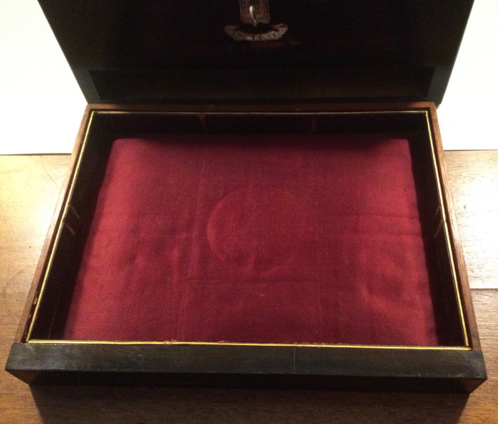 An early Victorian rectangular dark brown coromandel wood box featuring mother-of-pearl inlaid shield and crest motifs on the top lid and front panel. View VI