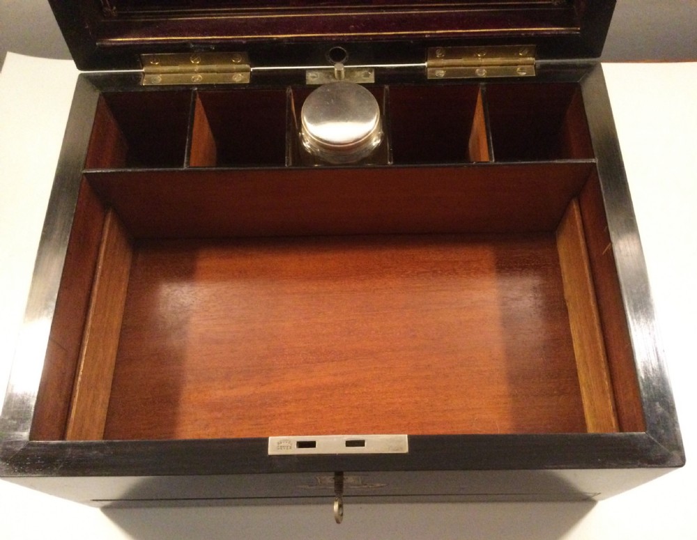 An early Victorian rectangular dark brown coromandel wood box featuring mother-of-pearl inlaid shield and crest motifs on the top lid and front panel. View VII