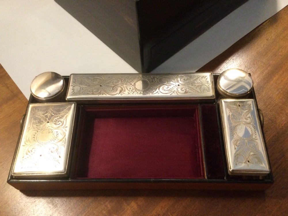 An early Victorian rectangular dark brown coromandel wood box featuring mother-of-pearl inlaid shield and crest motifs on the top lid and front panel. View VIII