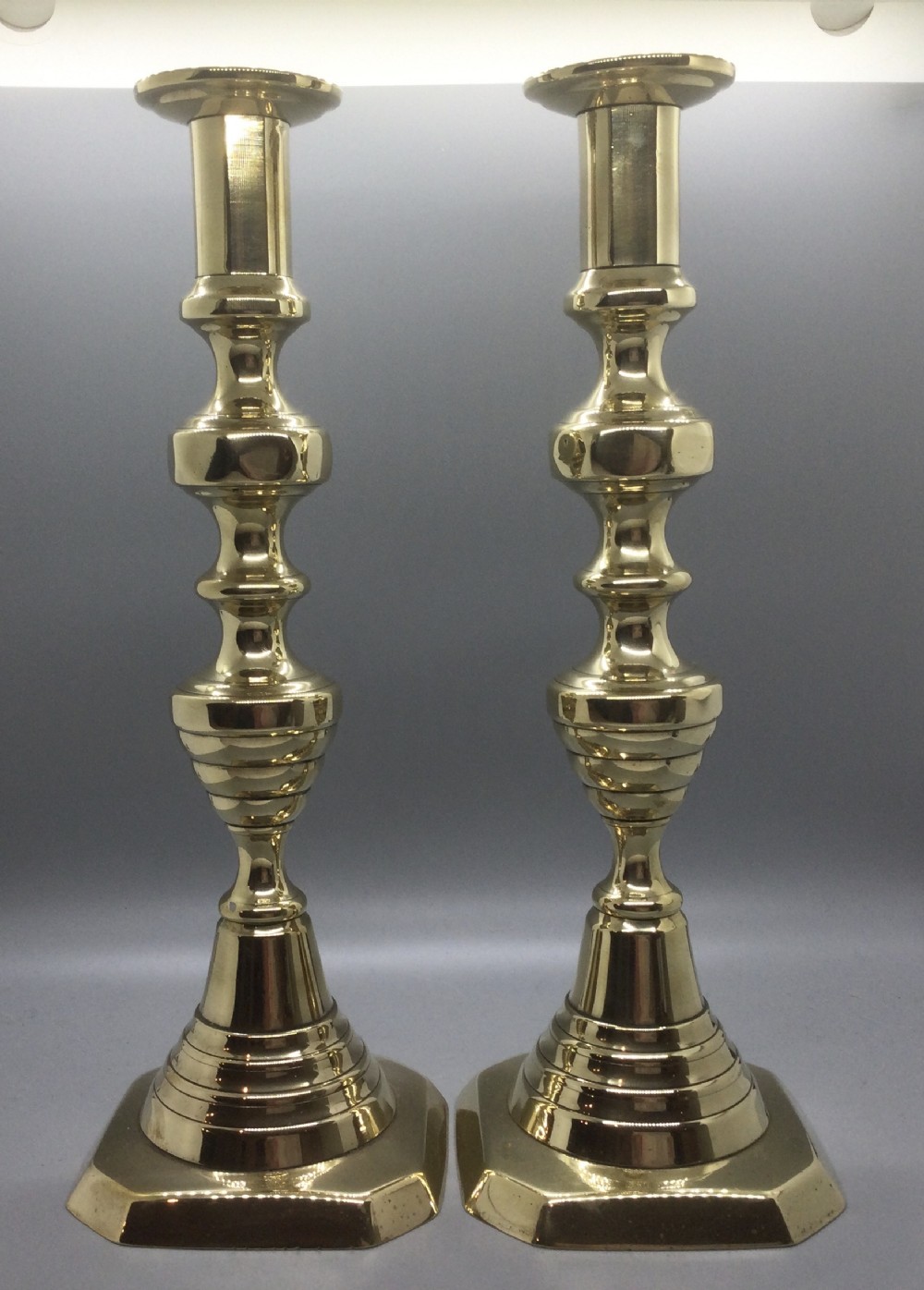 Early 19thC pair of graduated brass candlesticks c1820