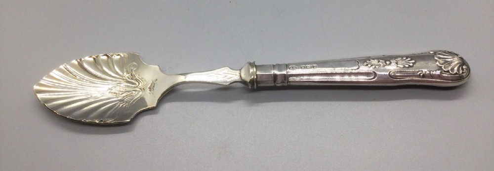 A three-piece Edwardian sterling silver serving set comprising a butter knife, pickle fork, and preserve spoon housed inside an open red velvet-lined presentation case. View IX