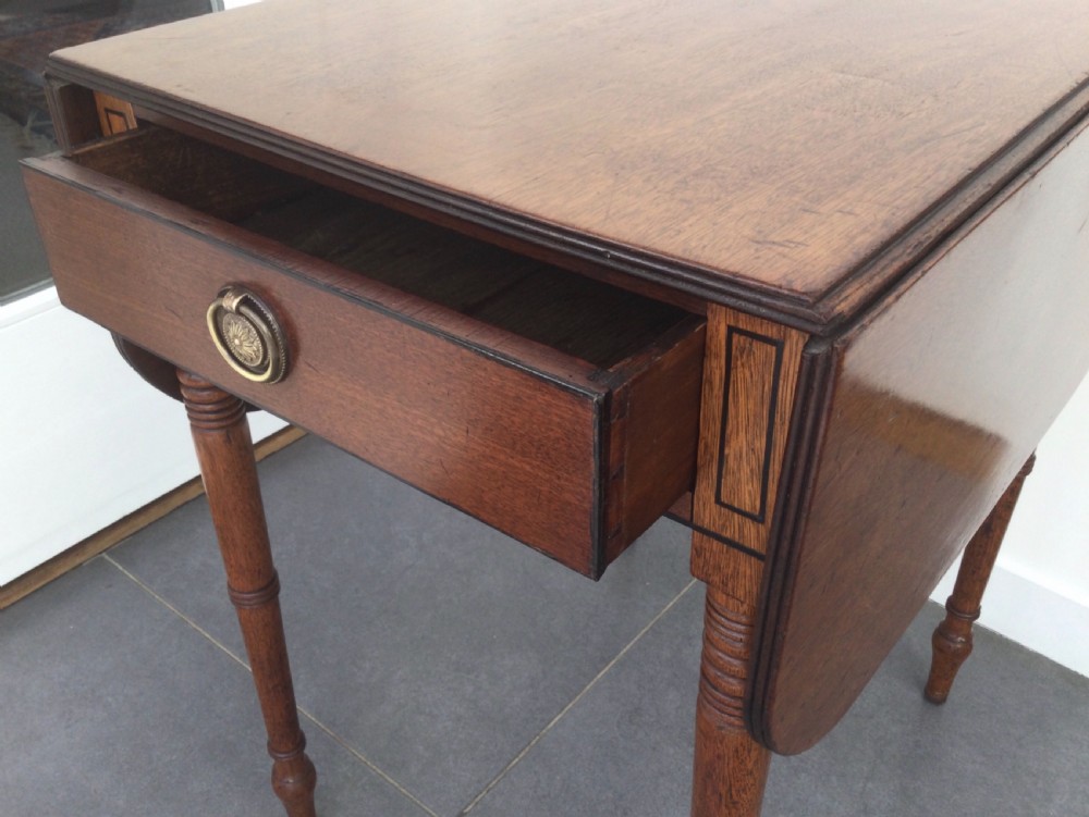 A Georgian mahogany drop leaf side table featuring a single drawer with a brass ring handle, inlaid border detailing, turned legs, and two hinged drop leaves. View X