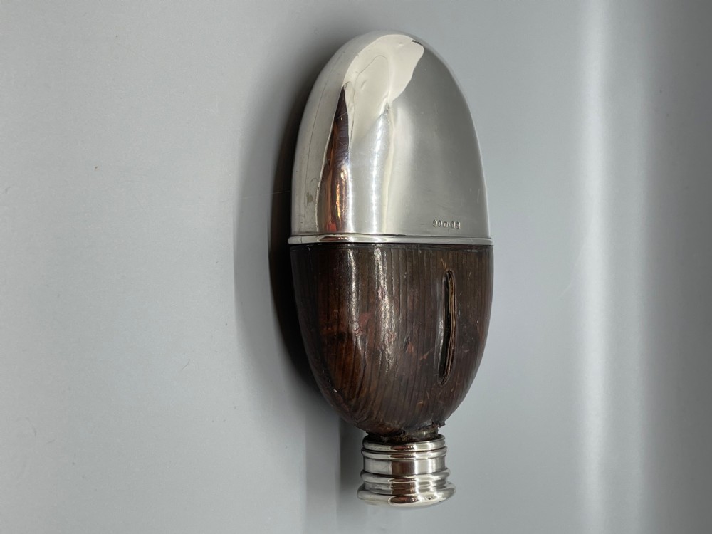 A Victorian spirit flask featuring a glass body encased in dark brown leather with a central sight window and a polished silver lower cup and cap. View IV