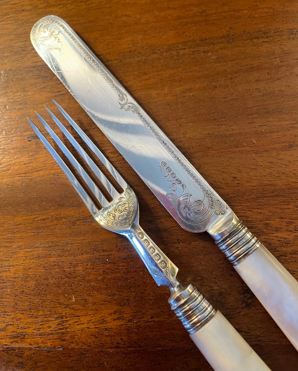 A Victorian silver-plated fruit cutlery set with mother-of-pearl handles displayed inside an open, blue velvet-lined wooden case. View VIII