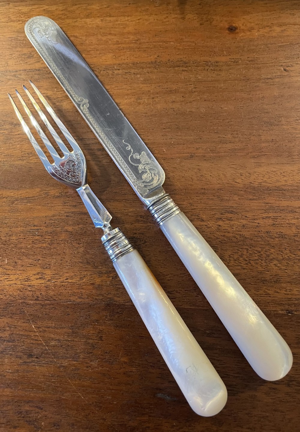 A Victorian silver-plated fruit cutlery set with mother-of-pearl handles displayed inside an open, blue velvet-lined wooden case. View IX