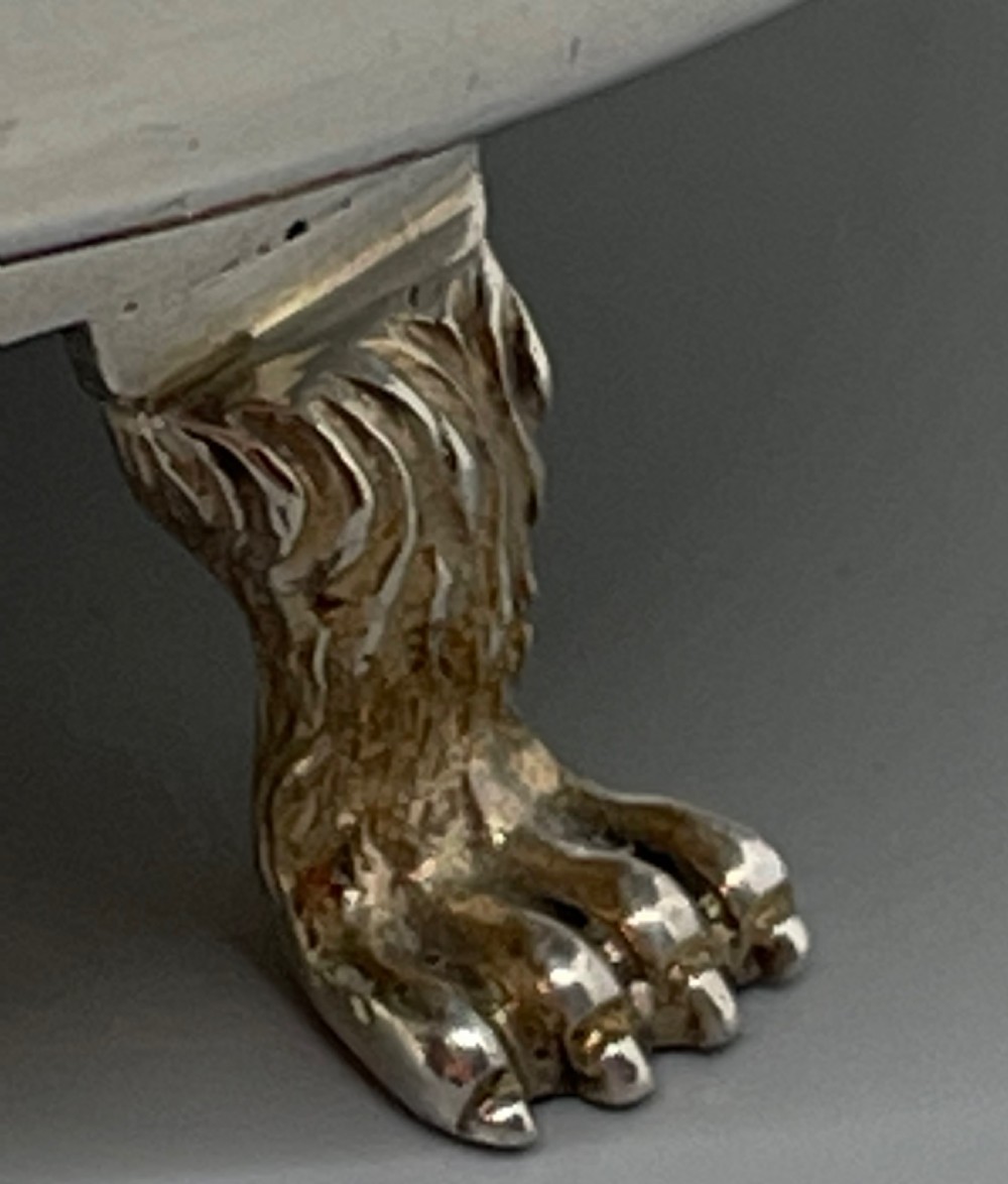 A pair of round Art Deco sterling silver bonbon dishes featuring twin scroll handles, lion paw feet, and visible Sheffield hallmarks. View IV