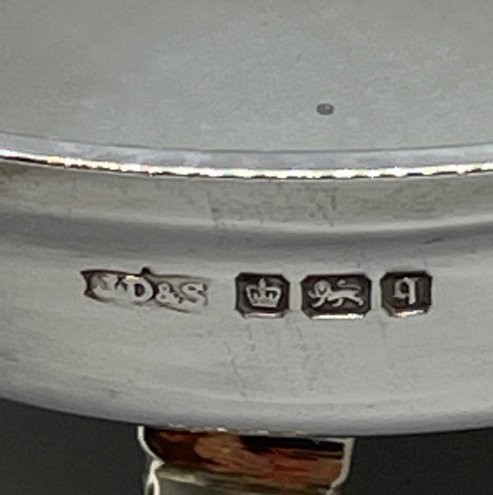A pair of round Art Deco sterling silver bonbon dishes featuring twin scroll handles, lion paw feet, and visible Sheffield hallmarks. View VII