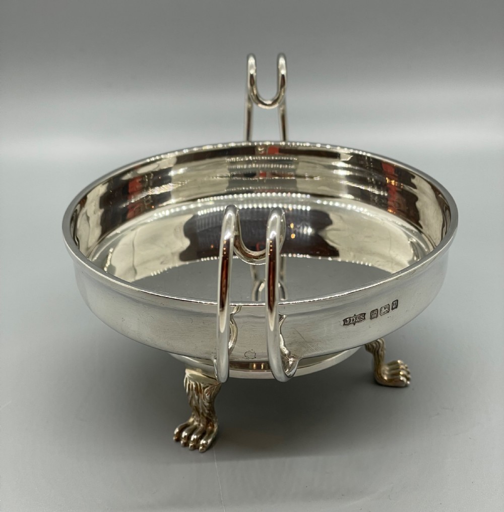 A pair of round Art Deco sterling silver bonbon dishes featuring twin scroll handles, lion paw feet, and visible Sheffield hallmarks. View XI