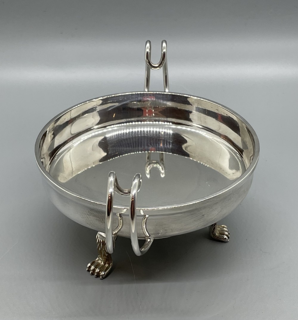 A pair of round Art Deco sterling silver bonbon dishes featuring twin scroll handles, lion paw feet, and visible Sheffield hallmarks. View XII