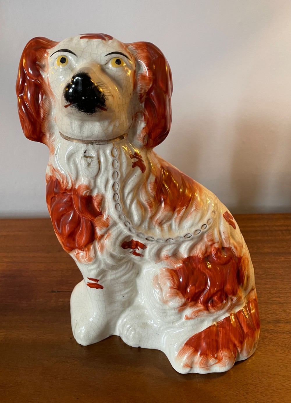 A pair of seated Victorian Staffordshire earthenware spaniel figurines featuring white glazed bodies with rust-red painted patches, black snouts, and gilded collars. View IX