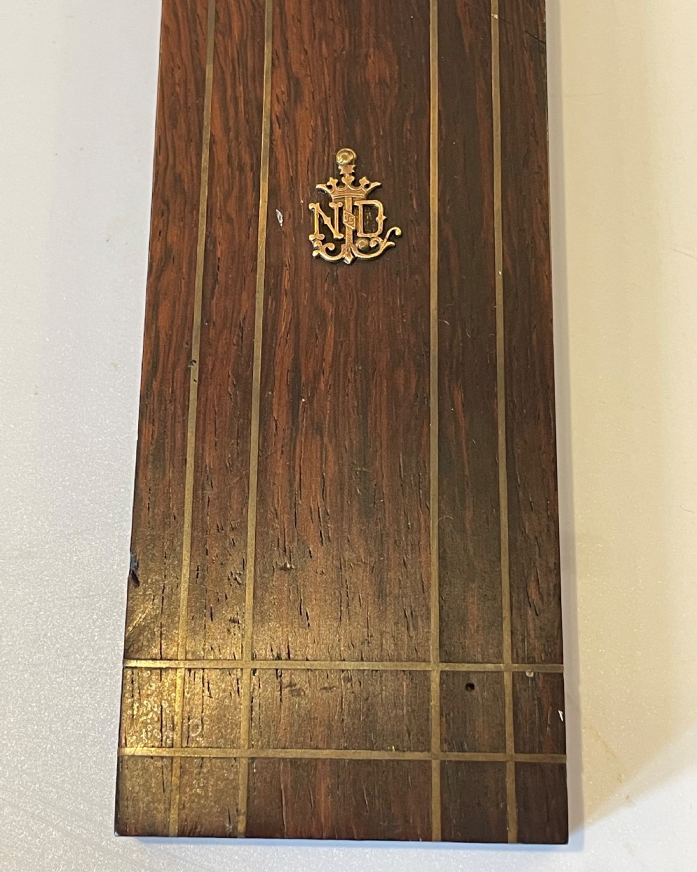 A dark rosewood wall crucifix featuring brass linear inlay, an ornate INRI plaque, a gilt metal figure of Christ, and a monogram emblem near the base. View VI