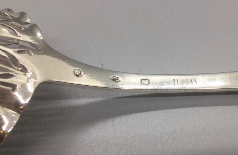 A nineteenth-century French silver sifter spoon featuring a scalloped pierced bowl and smooth curved handle. View VI
