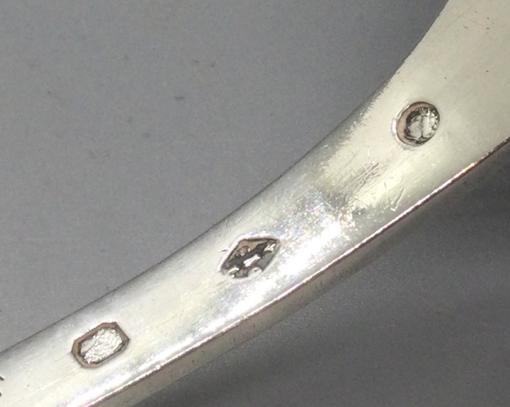 A nineteenth-century French silver sifter spoon featuring a scalloped pierced bowl and smooth curved handle. View VII