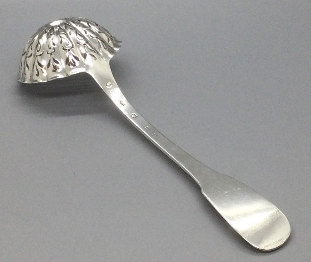 A nineteenth-century French silver sifter spoon featuring a scalloped pierced bowl and smooth curved handle. View X