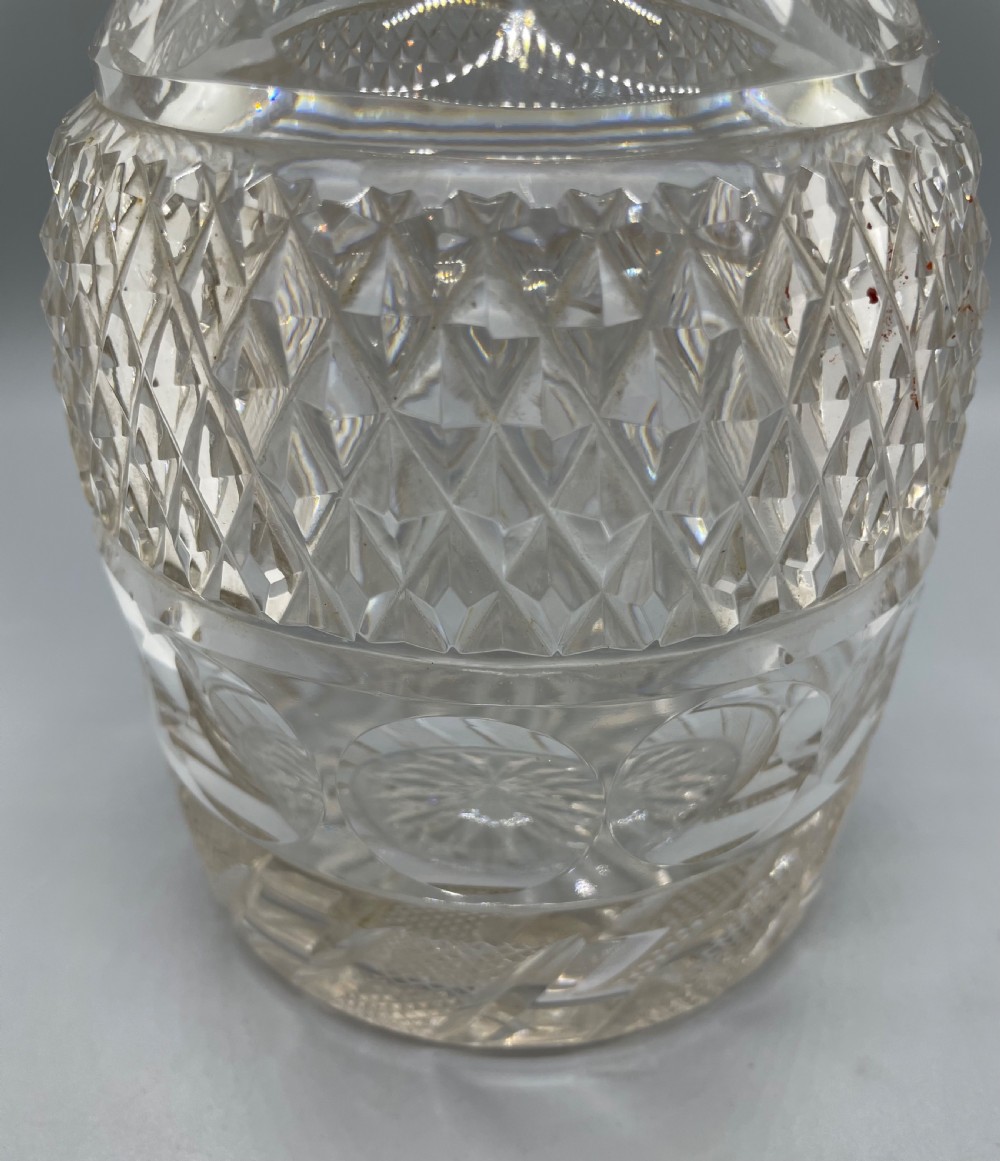 A clear cut lead crystal decanter featuring diamond cutting, a ringed neck, and a star-cut flat stopper. View II
