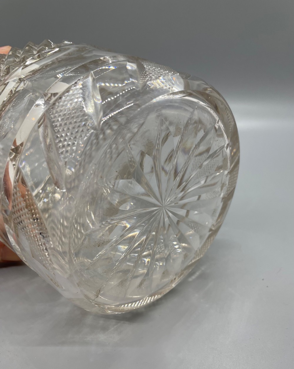 A clear cut lead crystal decanter featuring diamond cutting, a ringed neck, and a star-cut flat stopper. View V