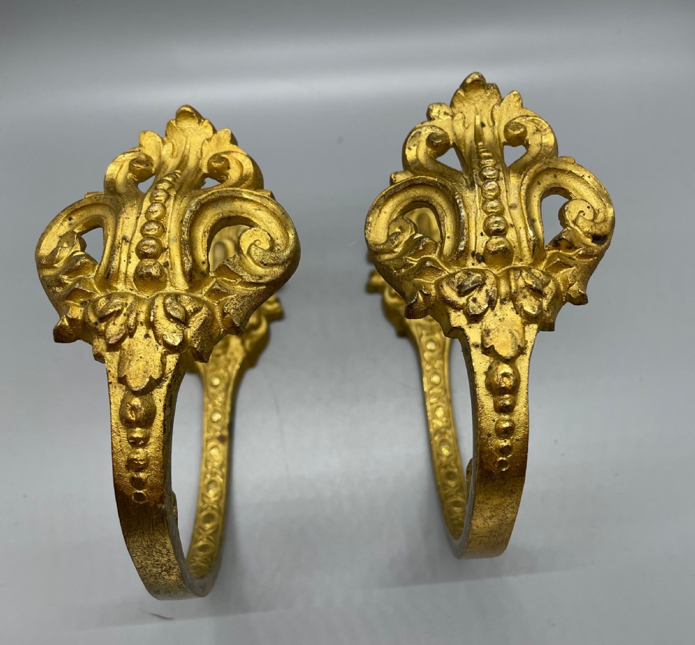 A pair of late nineteenth-century French ormolu curtain tiebacks featuring acanthus leaf scrollwork and beaded detail. View II