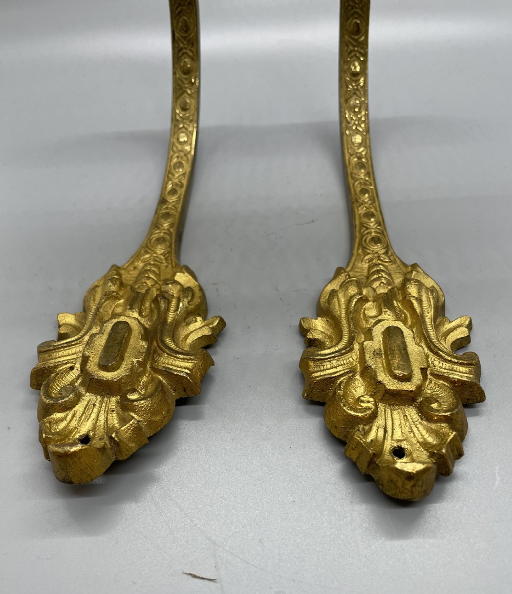 A pair of late nineteenth-century French ormolu curtain tiebacks featuring acanthus leaf scrollwork and beaded detail. View III
