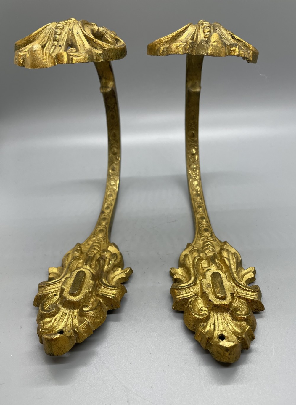 A pair of late nineteenth-century French ormolu curtain tiebacks featuring acanthus leaf scrollwork and beaded detail. View V